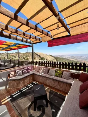 a rooftop patio with a couch and a table at شاليه بانا جرش jerash