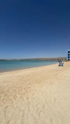 two people sitting in a chair on a beach at Cozy Apartment with Private Beach, couples and families only in Aqaba