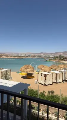 a beach with a bunch of umbrellas and the water at Cozy Apartment with Private Beach, couples and families only in Aqaba