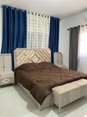 a bedroom with a large bed with blue curtains at Murjan in Amman
