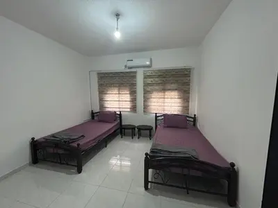 two beds in a room with purple sheets at Murjan in Amman