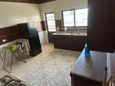 a kitchen with a black refrigerator and a sink at Murjan in Amman