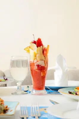 a vase filled with fruit and a drink on a table at Armada Avenue Hotel Amman in Amman