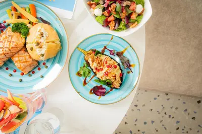 a table with three plates of food and a salad at Armada Avenue Hotel Amman in Amman