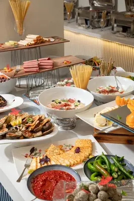 a table with many plates of food on it at Armada Avenue Hotel Amman in Amman