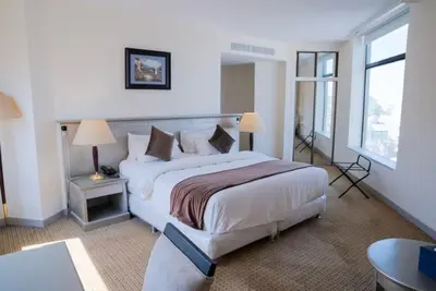 a hotel room with a large bed and a window at Armada Avenue Hotel Amman in Amman
