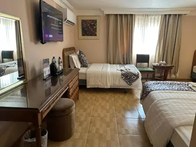 a hotel room with two beds and a flat screen tv at Mass Plaza Hotel in Aqaba