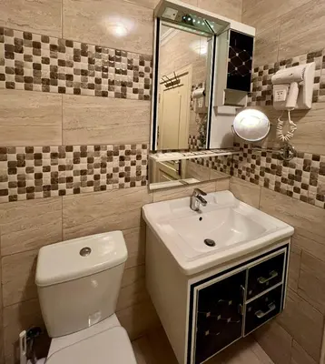 a bathroom with a white toilet and a sink at Mass Plaza Hotel in Aqaba