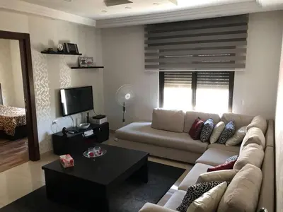 a living room with a couch and a table at Peaceful apartment in Amman 7th Circle near Cozmo in Amman