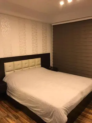 a bedroom with a large bed with white sheets at Peaceful apartment in Amman 7th Circle near Cozmo in Amman