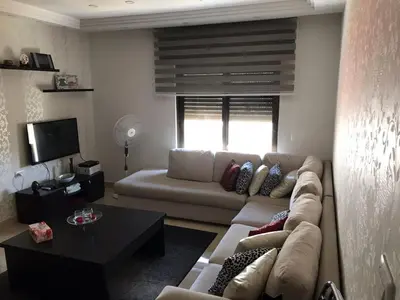 a living room with a couch and a table at Peaceful apartment in Amman 7th Circle near Cozmo in Amman