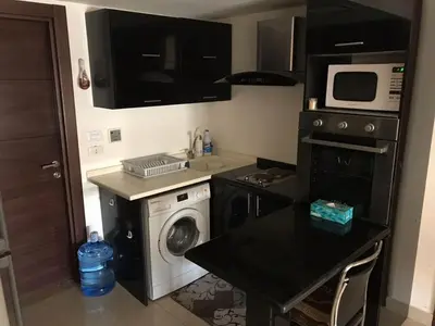 a kitchen with a washing machine and a microwave at Peaceful apartment in Amman 7th Circle near Cozmo in Amman