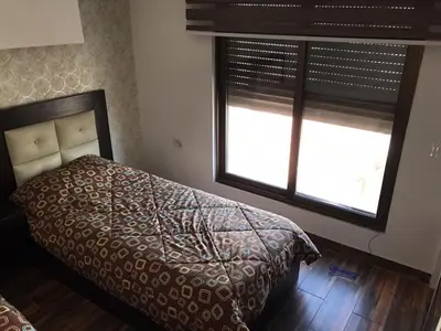 a bedroom with a bed and two windows at Peaceful apartment in Amman 7th Circle near Cozmo in Amman