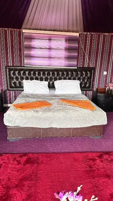 a bedroom with a large bed with a red carpet at Sultan rum magic camp in Aqaba