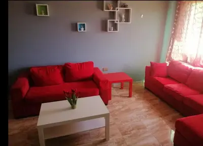 a living room with a red couch and a table at Humble house in Amman