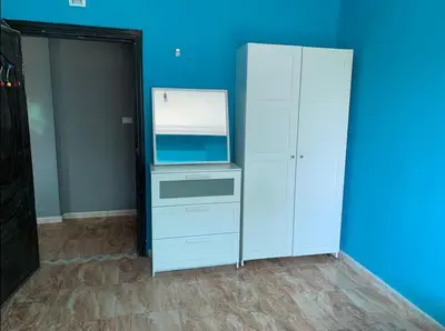 a room with a white cabinet and a blue wall at Humble house in Amman