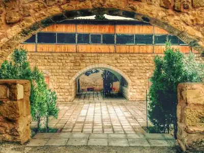 a stone wall with an archway in a building at Tafila-Mataan in Al Jafr