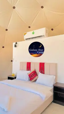 a bedroom with a bed with a sign on the wall at RUM GALAXY lUXURY CAMP in Disah