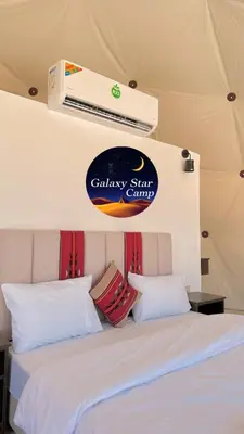 a bedroom with two beds and a sign on the wall at RUM GALAXY lUXURY CAMP in Disah