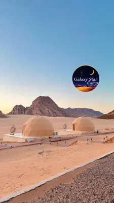 a hot air balloon flying over two domes in the desert at RUM GALAXY lUXURY CAMP in Disah