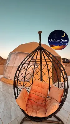 a bird cage with a chair in front of a tent at RUM GALAXY lUXURY CAMP in Disah