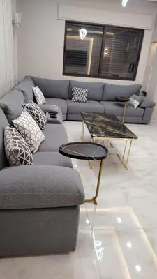 a living room with a couch and a table at شقة واسعة مع ترس كبير in Amman