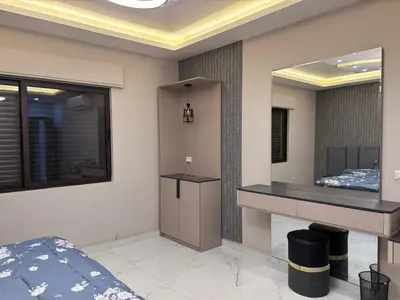 a bedroom with a bed and a large mirror at شقة واسعة مع ترس كبير in Amman