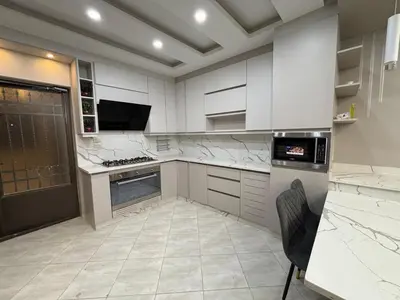 a kitchen with white counters and a stove top oven at شقة واسعة مع ترس كبير in Amman