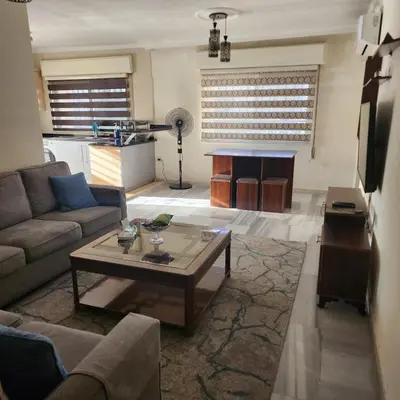 a living room with a couch and a table at Eyad's Apartment in Amman