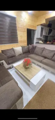 a living room with a couch with a vase on a table at Moose house in Ajloun