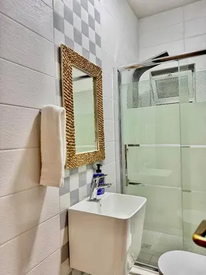 a bathroom with a sink and a shower and a mirror at Modern Apartment in Prime Location - Jabal Amman in Amman