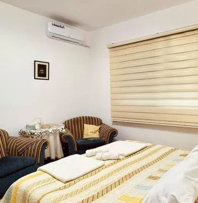 a bedroom with a bed and a table and chairs at Modern Apartment in Prime Location - Jabal Amman in Amman