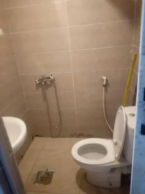 a small bathroom with a toilet and a shower at يرموك هاوس in Aş Şarīḩ