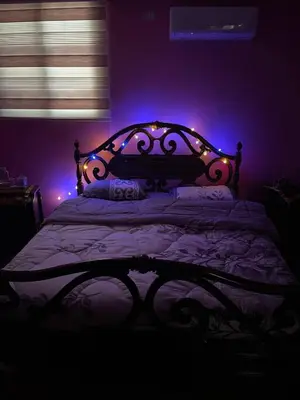 a bedroom with a bed with purple lights on it at Luxury couple room in irbid in Irbid