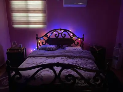 a bedroom with a bed with purple lights on it at Luxury couple room in irbid in Irbid