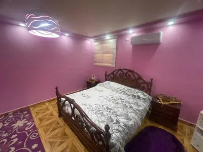 a bedroom with a wooden bed with purple walls at Luxury couple room in irbid in Irbid