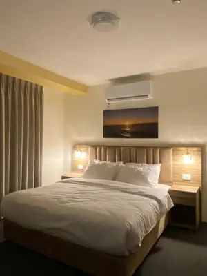 a bedroom with a white bed with two night stands and two lamps at Petra Jewel Hotel in Wadi Musa