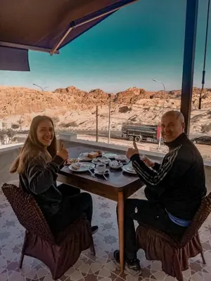 a man and a woman sitting at a table with food at Petra Jewel Hotel in Wadi Musa