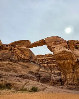 an arch in the side of a rock formation at Kinda Rum Luxury Camp in Wadi Rum