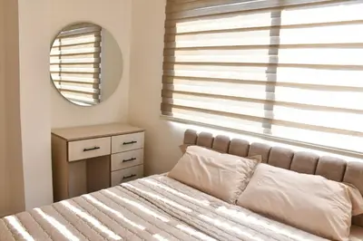 a bedroom with a bed and a mirror and a window at Furnished Apartment شقة مفروشة in Irbid