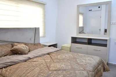 a bedroom with a bed with a dresser and a mirror at Furnished Apartment شقة مفروشة in Irbid