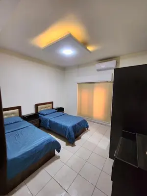 a bedroom with two beds and a projection screen at Family apartment in Abdoun Al Janobi in Amman