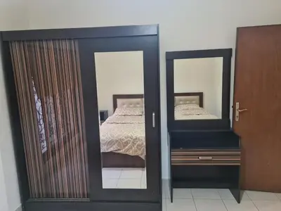 a bedroom with a bed and two mirrors at Family apartment in Abdoun Al Janobi in Amman