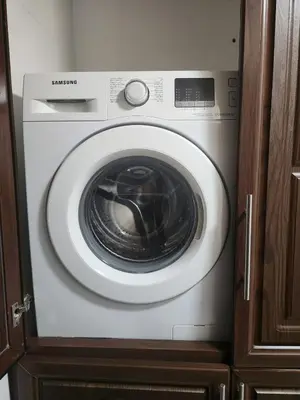 a white washing machine in a cabinet in a kitchen at 4th circle embassy district 2 bedrooms الدوار الرابع حي السفارات in Amman