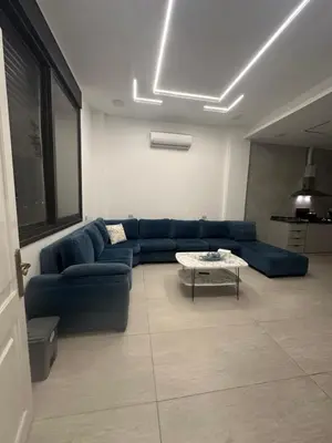 a living room with a blue couch and a table at Hassan villa in Sākib