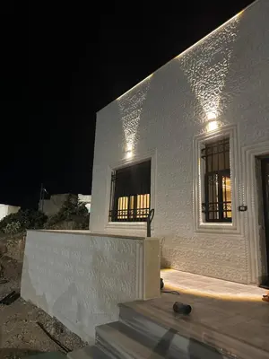 a white building with a window at night at Hassan villa in Sākib