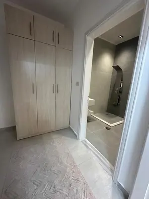 a bathroom with a walk in shower and a treadmill at Hassan villa in Sākib