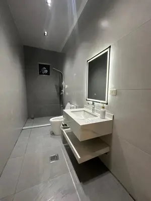 a bathroom with a sink and a toilet and a television at Hassan villa in Sākib