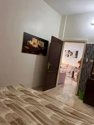 a bedroom with a bed and a picture on the wall at دار زمان Zaman Suites Old Town in Al Mafraq