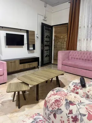 a living room with a pink couch and a table at دار زمان Zaman Suites Old Town in Al Mafraq